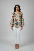  wearing a floral and bird patterned top with a white background