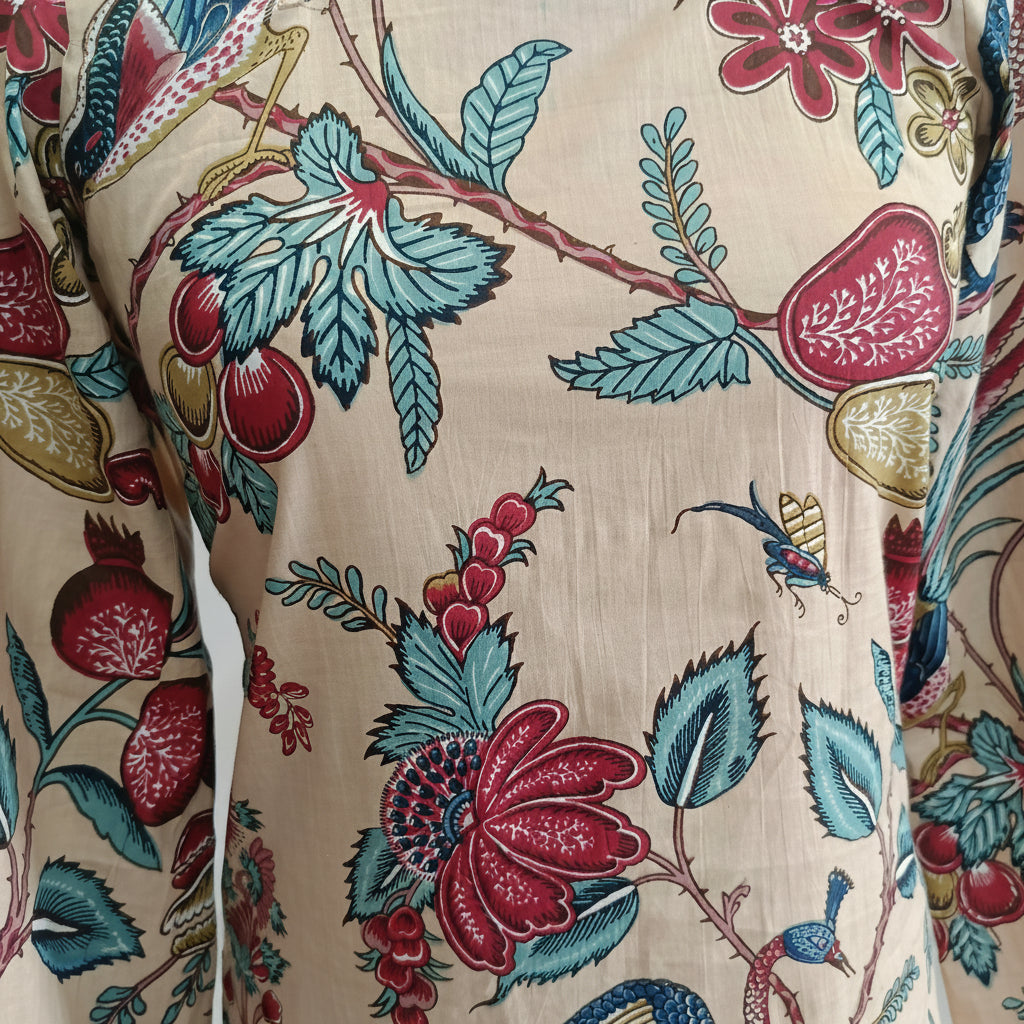 Close-up of fabric with a colorful floral and fruit pattern on a beige background