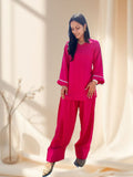Woman wearing a pink farsi salwar set against a neutral background