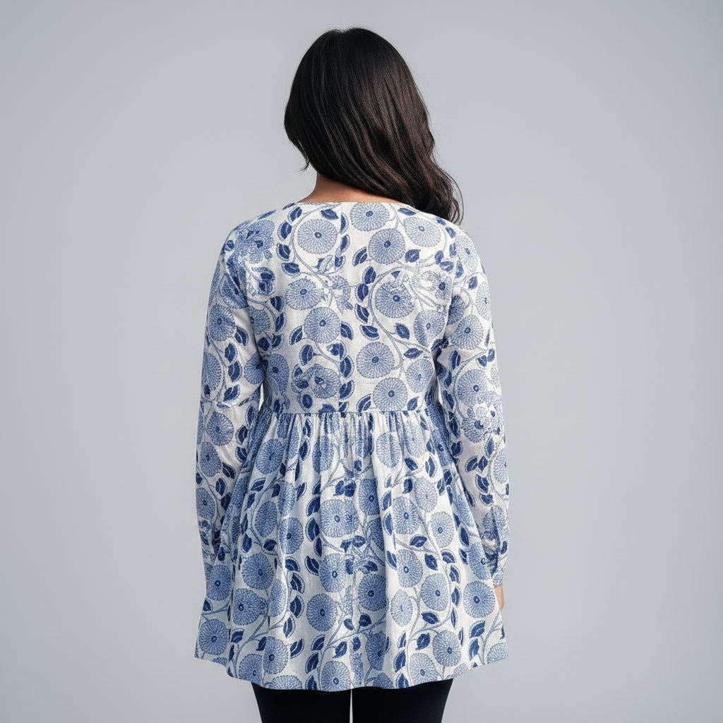 Two women wearing blue floral kurti standing in front of a cardboard box with text.