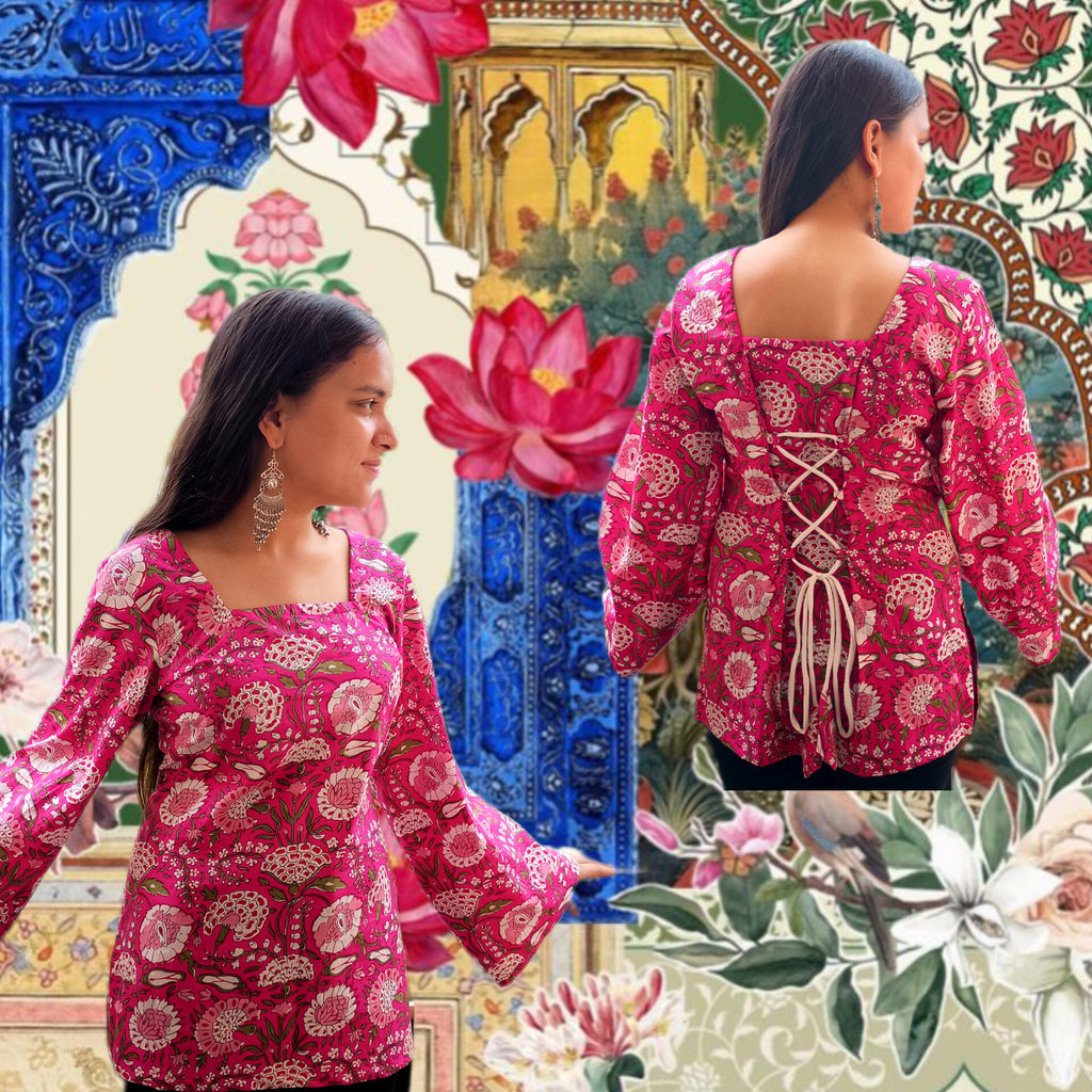 Two women wearing pink floral traditional outfits with a colorful, patterned background.