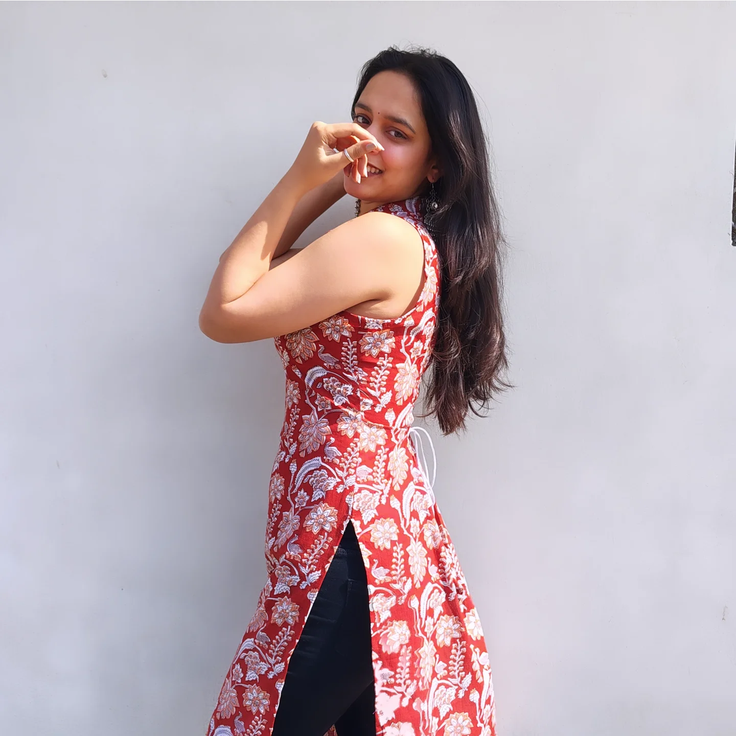 Woman wearing a halter neck long kurti against a plain background