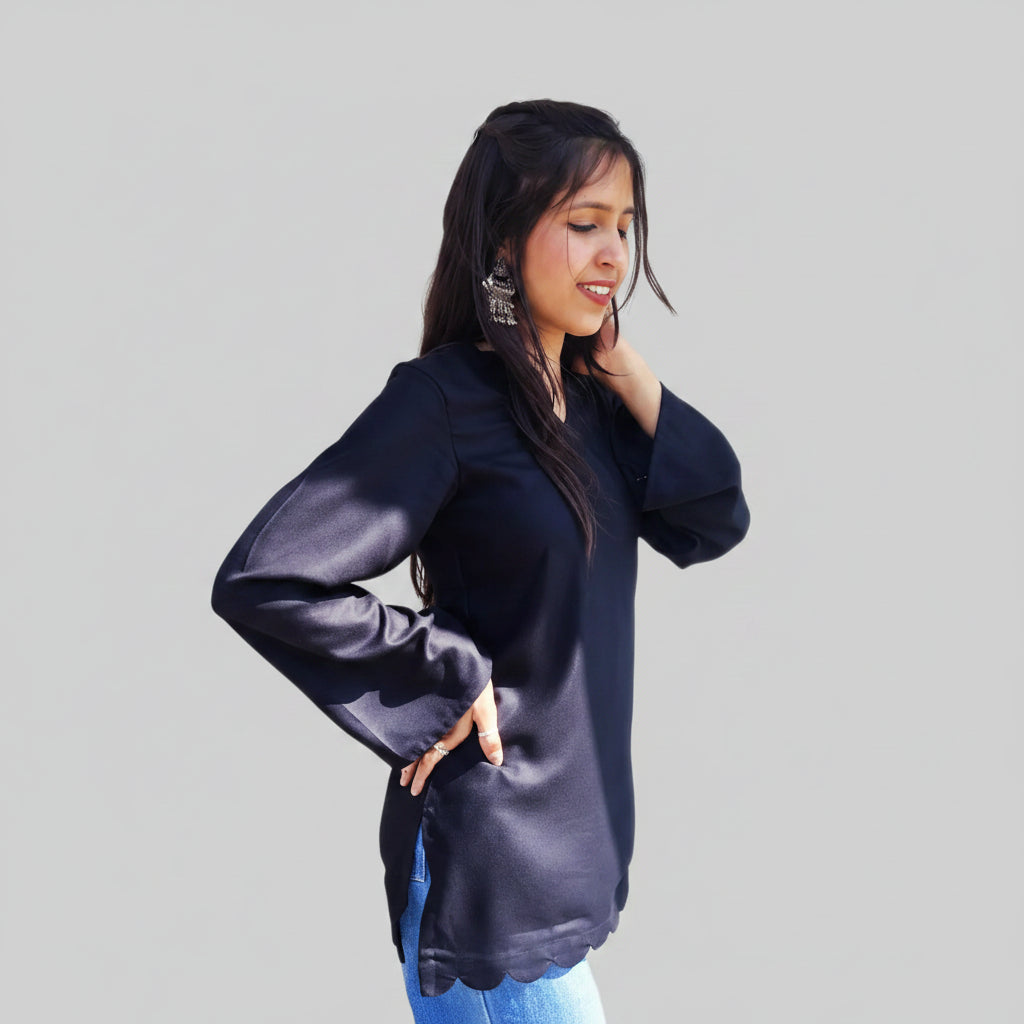 Woman wearing a black long-sleeve top with text indicating 'Straight sleeves' and 'Sealed hemline' .