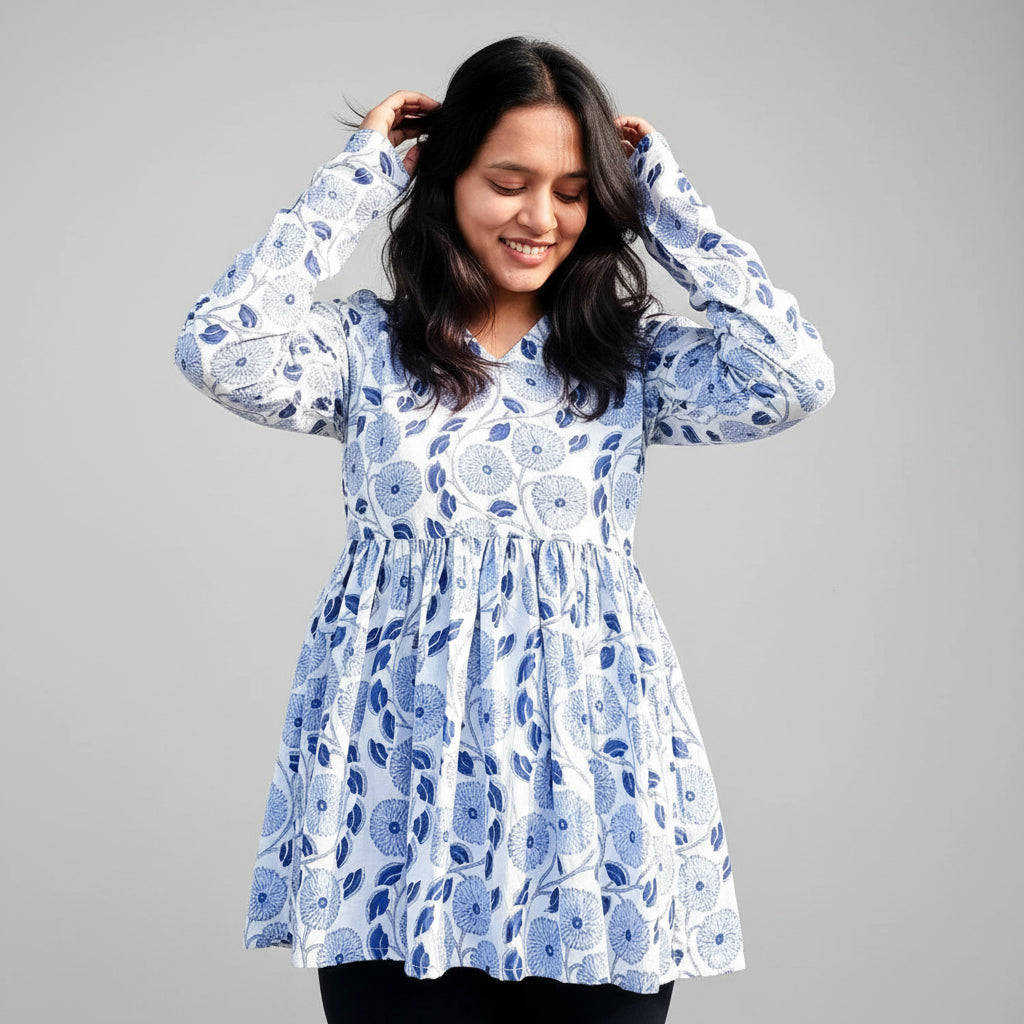 Woman wearing a blue floral kurti on a textured background.