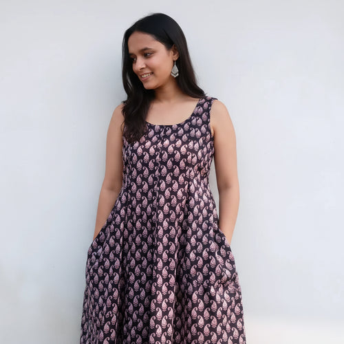Woman wearing a patterned dress against a plain background