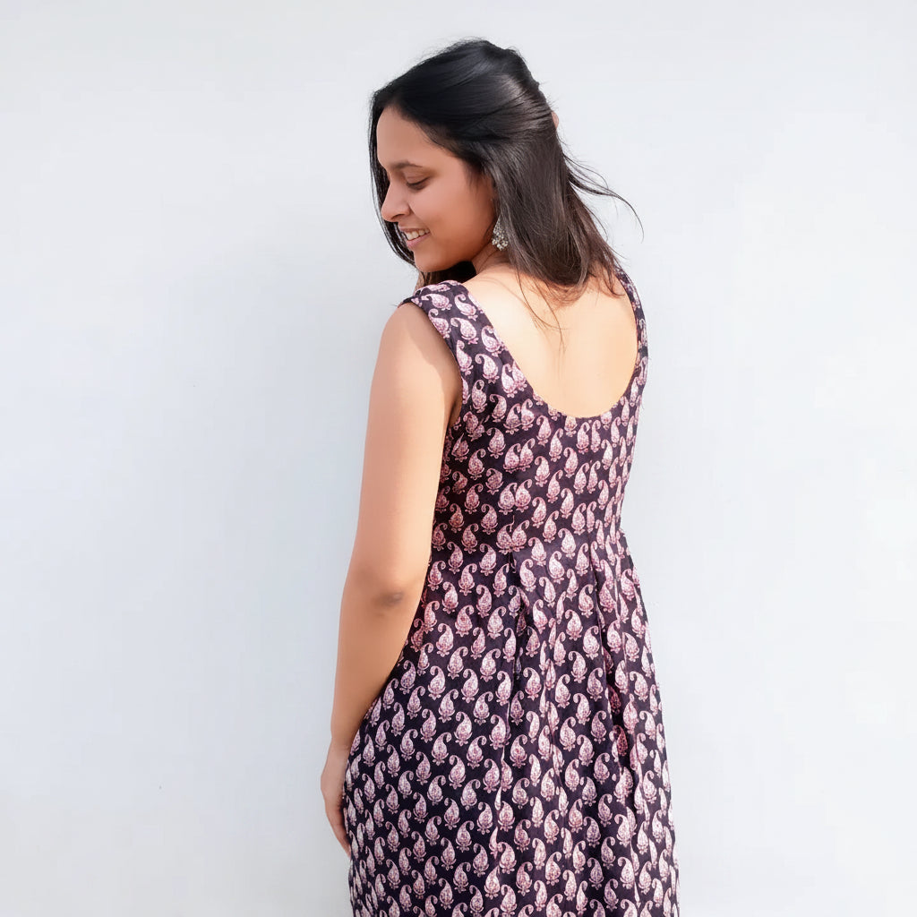 Woman wearing a patterned dress against a plain background